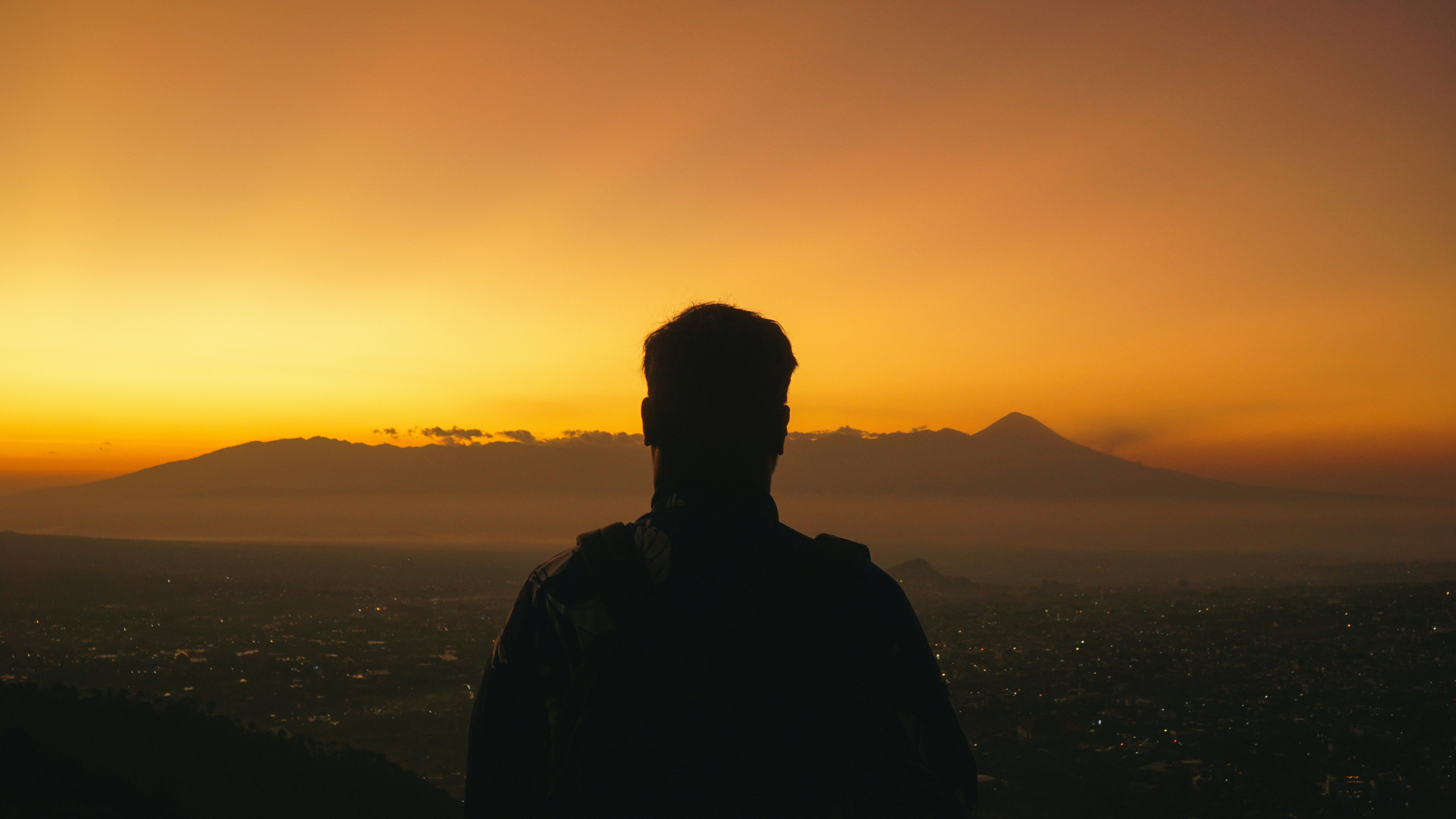 Силует воїна на вершині гори в променях бурштинового сонця